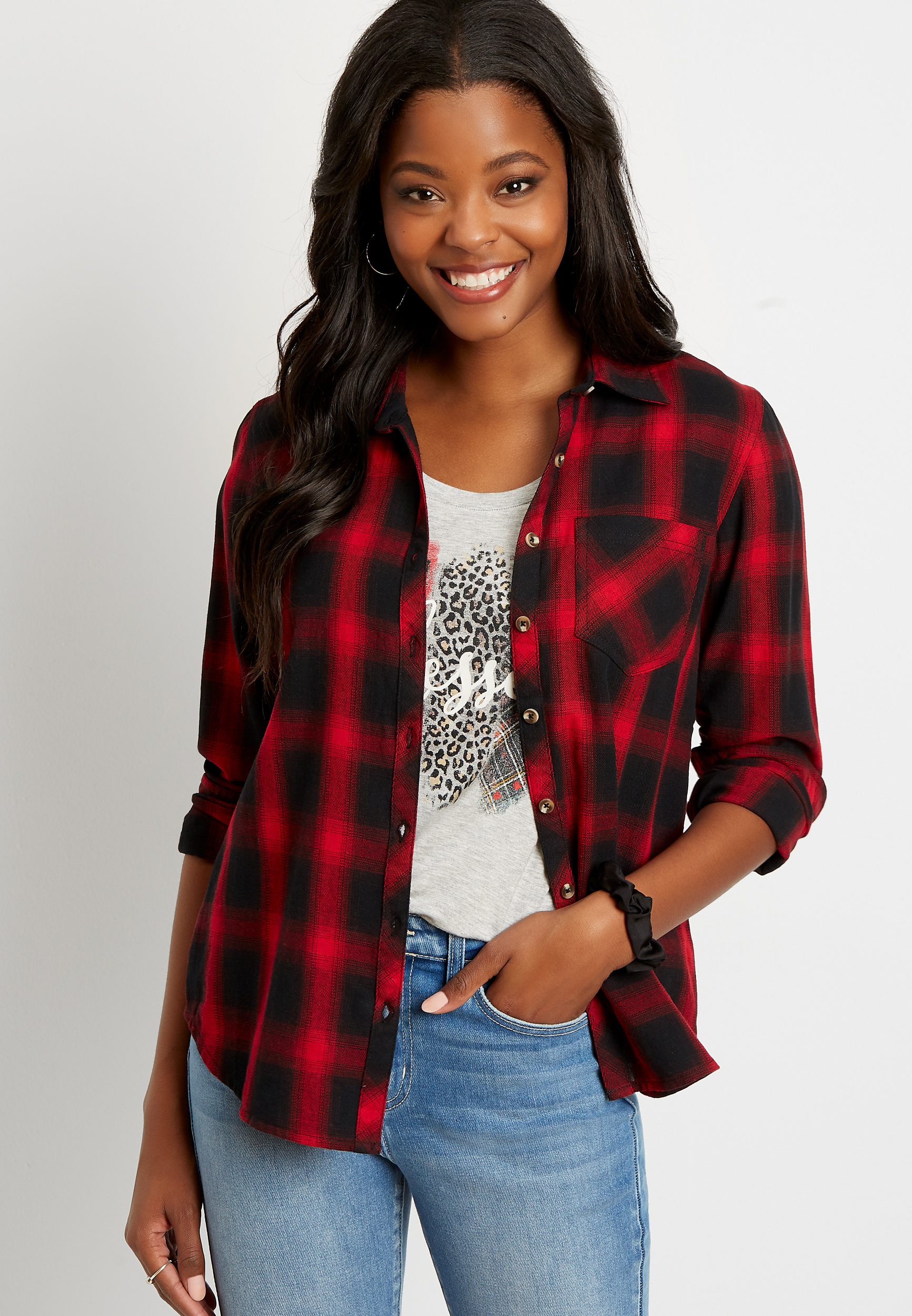 Closeup of three women hugging, wearing red plaid shirts and black